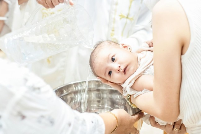baby being baptised over a font