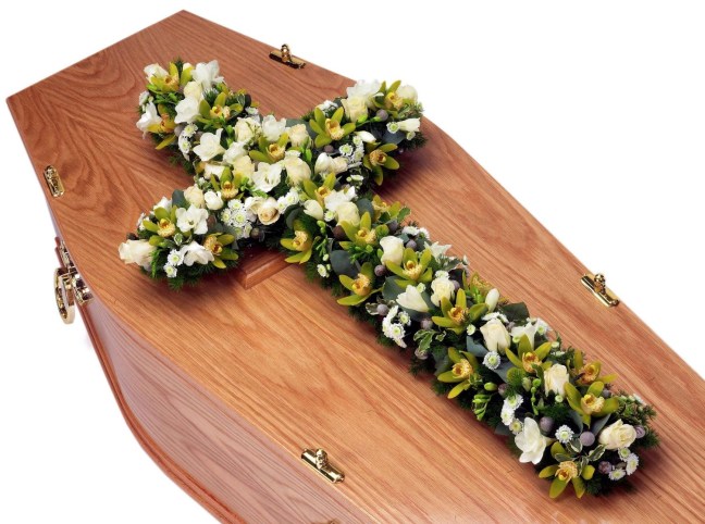 Coffin topped by a cross of white flowers